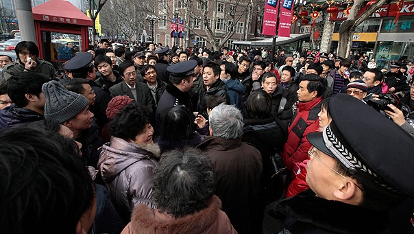 Feb. 20 Police officers urge people to leave as they gather in front of a cinema that was a planned protest site in Shanghai, China