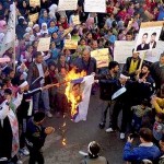 Demonstrators burn an image of Syrian President Bashar Al-Assad during a demonstration